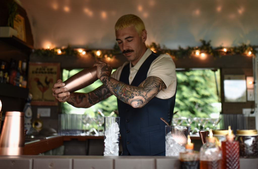 bartender preparing signature cocktail for a wedding mobile bar